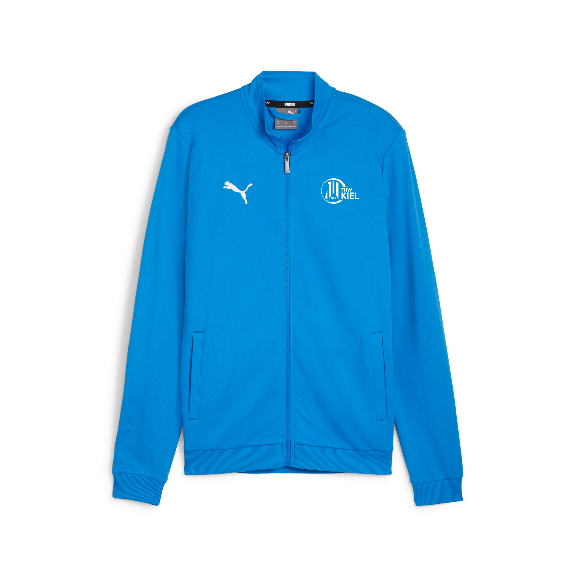 Die teamGOAL Casual Tracktop Ignite Blue Jacke von Puma aus Polyester hat einen Reißverschluss sowie das Puma-Logo rechts und das weiße "Kiel"-Emblem links auf der Brust, präsentiert auf weißem Hintergrund.