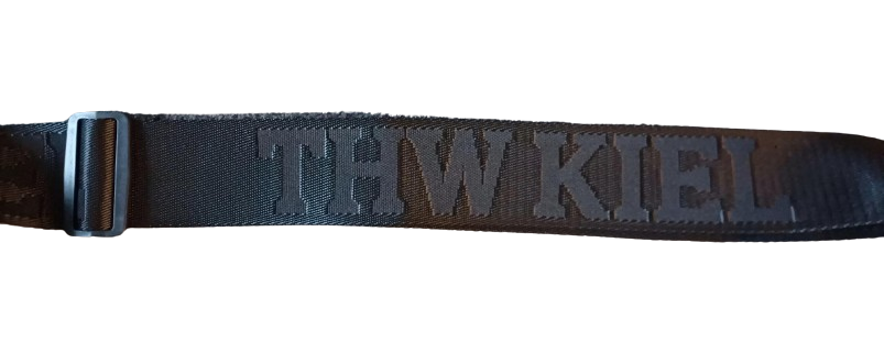 Eine Nahaufnahme des schwarzen Stoffriemens der Cross Body Bag BUCKLE schwarz mit dem aufgestickten Schriftzug "THW KIEL" und einer verstellbaren schwarzen Schnalle auf der linken Seite.