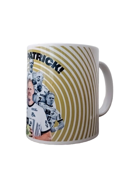 Ein weißer Becher mit goldenem Kreismuster, Rugbyspielern in weißen Trikots und dem fetten schwarzen Schriftzug "PATRICK!" - eine perfekte Hommage an das Bundle Abschiedsspiel 17 Wiencek und die Aufregung eines Handball-Abschiedsspiels.