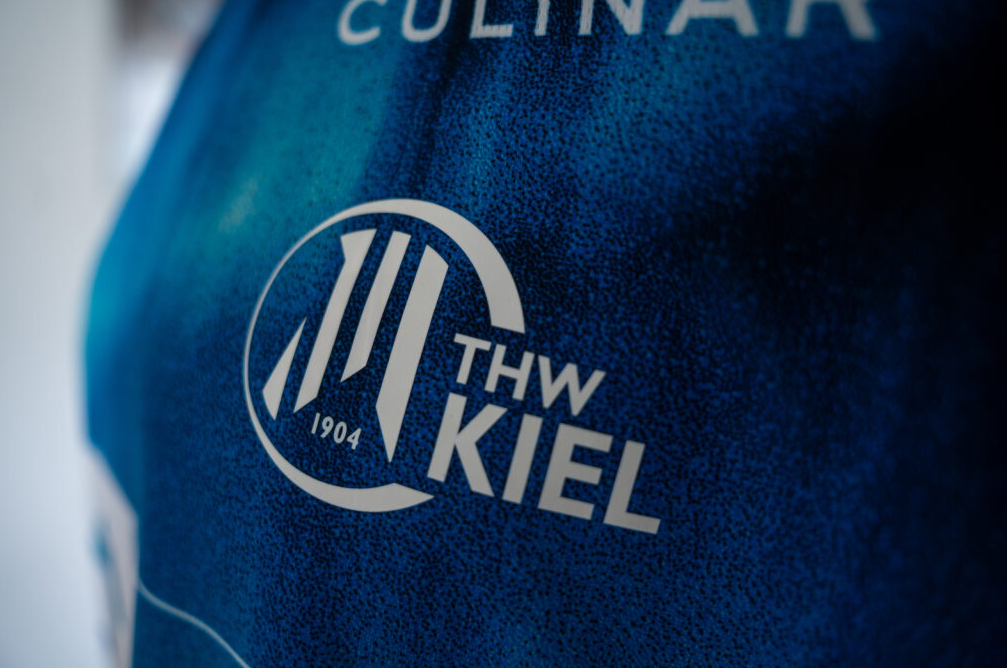 Nahaufnahme des THW Kiel 25-26 Auswärtstrikots PUMA Navy, mit dem weißen THW KIEL 1904-Logo, drei stilisierten Linien und einem teilweise sichtbaren CULINAR-Schriftzug am oberen Rand.