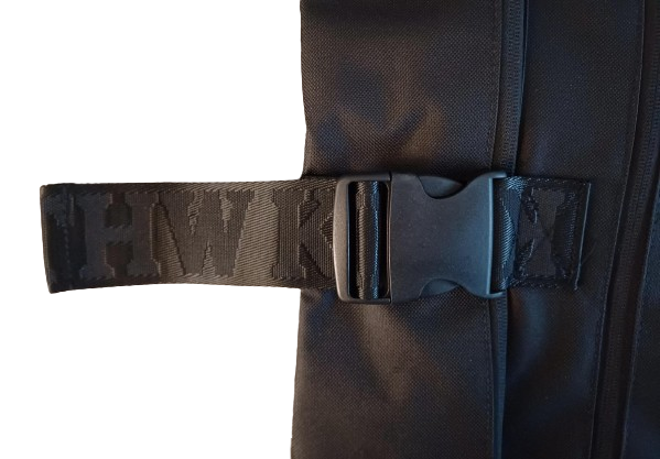 Nahaufnahme einer seitlichen Schnalle aus schwarzem Kunststoff an einem Stoffband mit dem fettgedruckten Schriftzug "THWKN", das am Rucksack BUCKLE schwarz befestigt ist, der über ein Laptopfach verfügt.