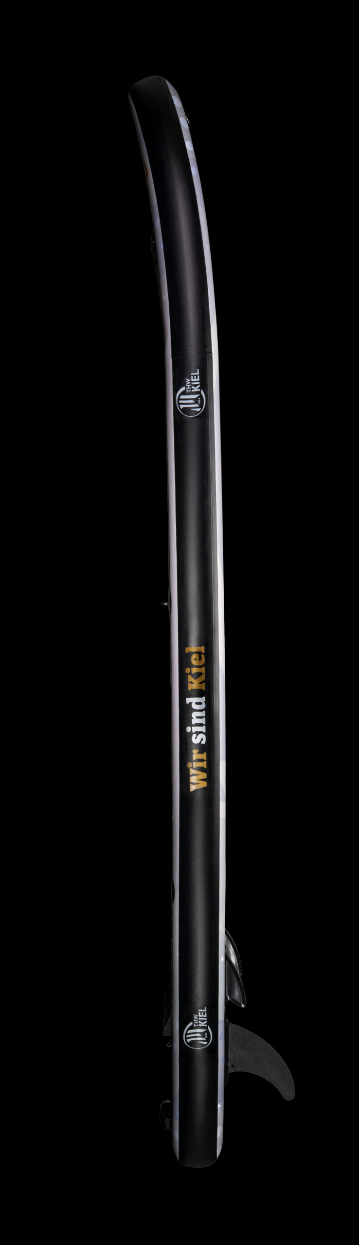 Das schwarze THW Kiel SUP limitiert steht senkrecht auf schwarzem Grund und zeigt weiße und gelbe Logos und Schriftzüge sowie eine Bodenflosse - ideal für Stand-Up-Paddling-Fans, die ein exklusives, limitiertes Board suchen.