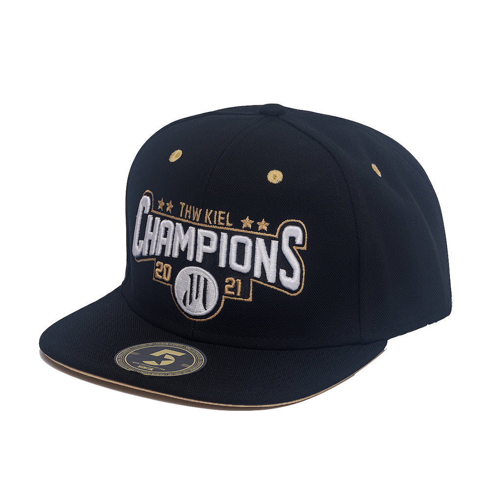Die Snapback Cap "CHAMPIONS" schwarz ist eine schwarze Kappe mit flacher Krempe und einer gold-weißen "Champions 2021"-Stickerei, drei Sternen darüber, einem eingekreisten zweizeiligen Logo und einem Aufkleber am Rand.