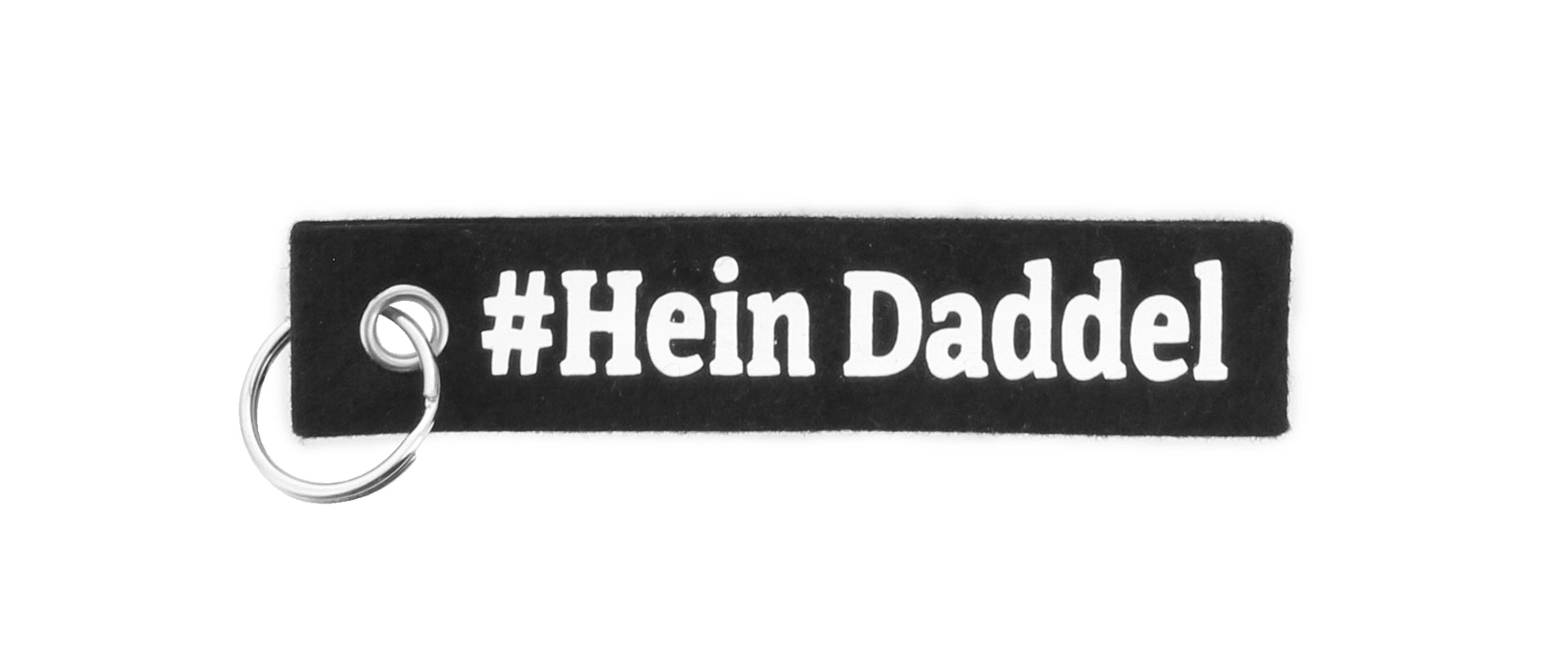 Der Schlüsselfilz ist ein schwarzer, rechteckiger Filz-Schlüsselanhänger mit einem Metallring und dem Schriftzug Hein Daddel" in weiß - perfekt für jeden THW Kiel Fan.
