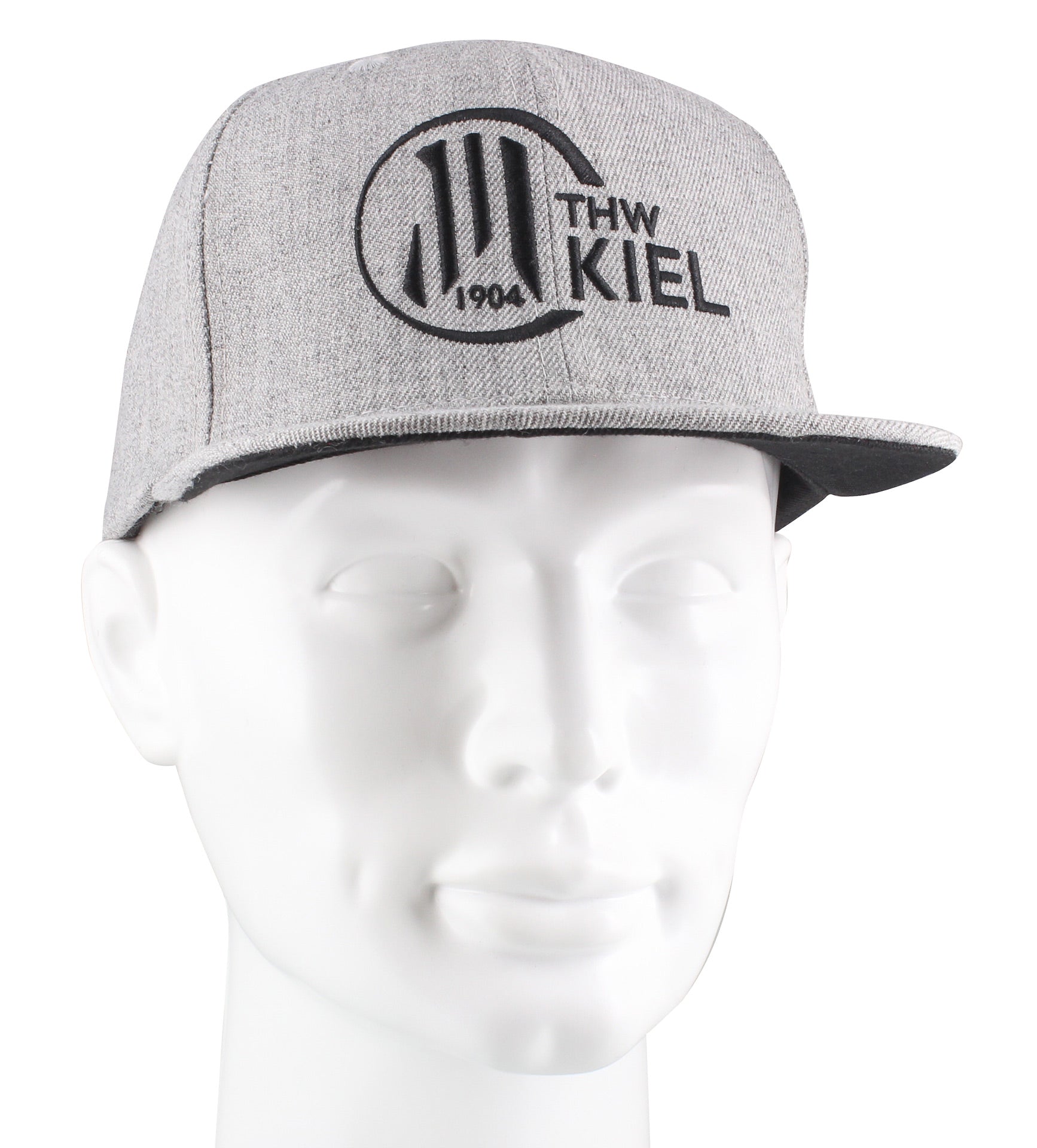 Die Snapback Cap grau hat eine schwarze 3D-Stickerei "THW KIEL 1904", die den Handball-Rekordmeister ehrt. Stilecht abgebildet auf einer weißen Schaufensterpuppe.