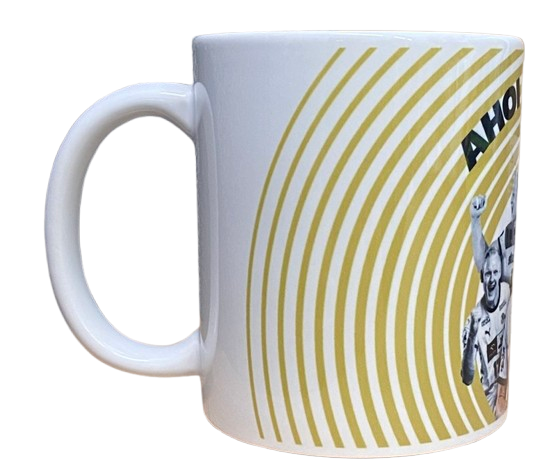 Ein weißer Becher mit gelben konzentrischen Kreisen und einem Teil einer Grafik mit einer erhobenen Faust sowie einem teilweise fettgedruckten Text "AHO" aus der Kollektion Bundle Abschiedsspiel 17 Wiencek.
