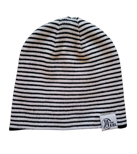 Die Beanie Kids schwarz-weiß ist eine schwarz-weiß gestreifte Mütze mit einem kleinen weißen Aufnäher am unteren Rand, der den Schriftzug "Tiny KIEL" und ein kreisförmiges Logo zeigt, inspiriert vom ikonischen Stil des THW Kiel.