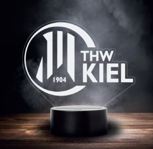 Ein runder, schwarzer Sockel projiziert das beleuchtete THW Kiel Logo mit 1904" und stilisierter weißer Schrift und sorgt so für eine auffällige LED Licht weiß Anzeige vor dunklem Hintergrund.