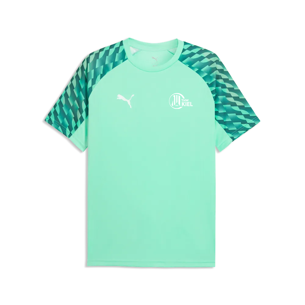 Das TeamLIGA26 Jersey Jr ist ein mintgrünes Kurzarm-Fußballtrikot aus recyceltem Polyester mit dunkelgrünen Ärmeln in geometrischem Muster, einem weißen PUMA-Logo auf der rechten Brustseite und einem weißen Kieler Vereinswappen auf der linken Brustseite.