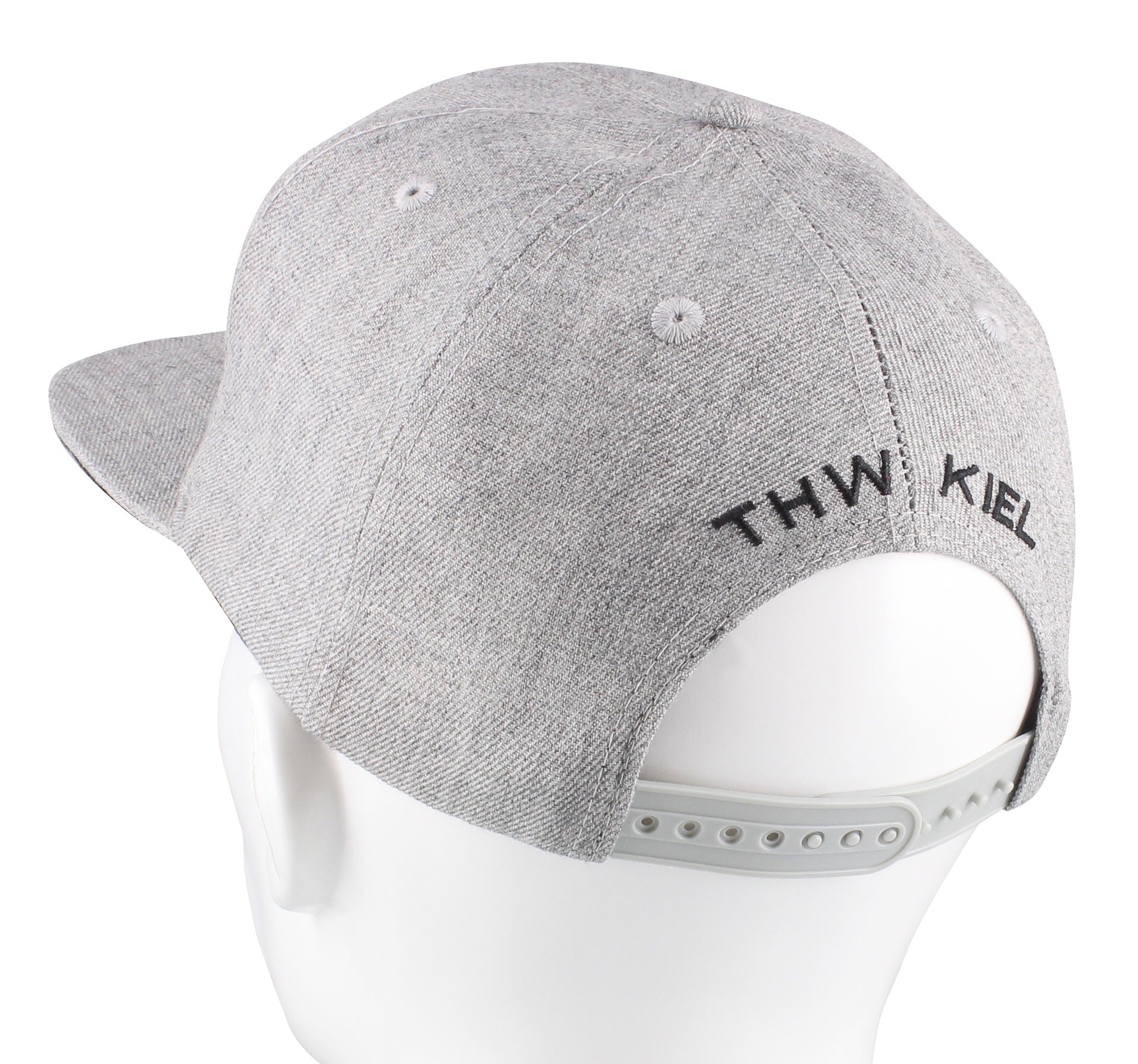Die Snapback Cap grau ist eine graue Kappe mit schwarzer Stickerei "THW KIEL" auf der Rückseite, abgebildet auf einem weißen Puppenkopf. Dieser Handball-Fanartikel verfügt über einen verstellbaren Snapback-Verschluss für mehr Komfort.